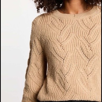 Camisola bege em malha texturizada com padrão trançado e gola redonda