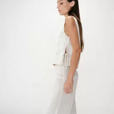 Conjunto feminino bege claro de linho composto por top sem mangas com laço lateral e calças compridas retas.
