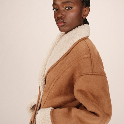 Mulher a usar casaco bege com interior e golas de pêlo sintético