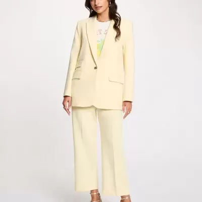 Conjunto amarelo claro de blazer e calças largas com sandálias douradas e camisola estampada