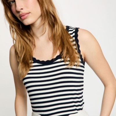 Regata listrada preta e branca com renda preta no decote, usada com calças brancas