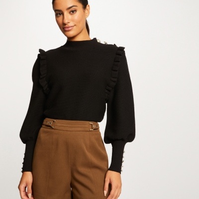 Blusa preta de malha com gola alta e calções castanhos