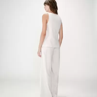 Conjunto feminino branco com colete e calças largas visto de costas
