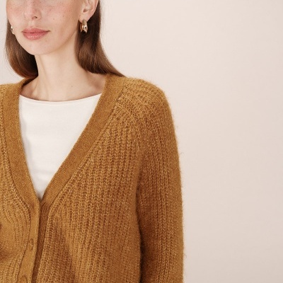 Cardigã castanho de malha com botões sobre t-shirt branca