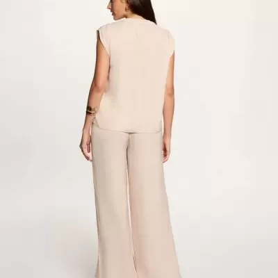 Conjunto feminino bege claro com blusa sem mangas e calças largas visto de costas