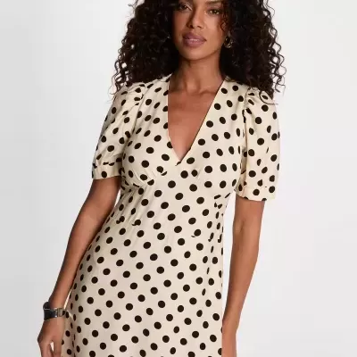 Vestido bege com bolinhas pretas, decote em V, mangas curtas franzidas