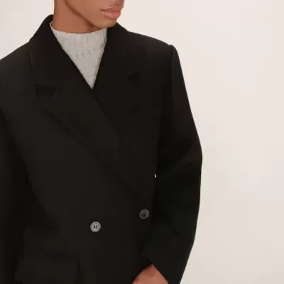 Casaco preto de tecido grosso com botões e lapelas largas