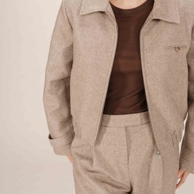 Casaco e calças bege com padrão espinha de peixe e t-shirt castanha