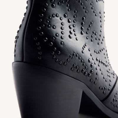 Botim preto em couro com salto grosso e detalhes em relevo