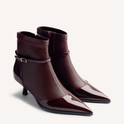 Botins de mulher castanhos escuros de couro com salto fino e bico pontiagudo.