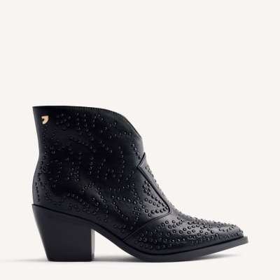 Botim de cano curto preto em pele com tachas decorativas e salto grosso.