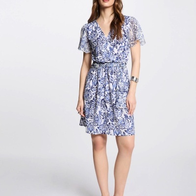 Vestido curto azul e branco com padrão floral e cinto, sandálias prateadas