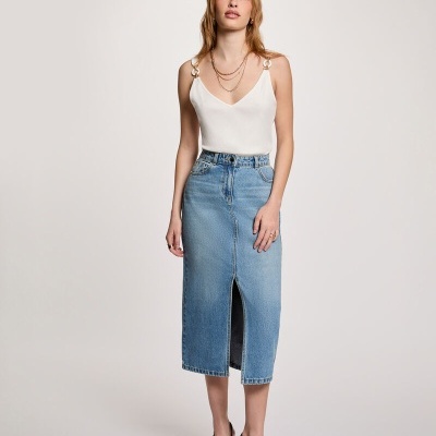 Mulher com blusa branca e saia midi de ganga azul