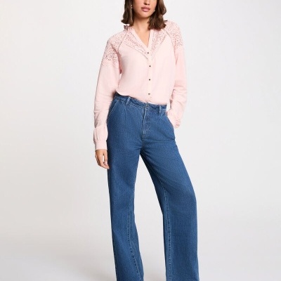 Mulher com camisa rosa e calças de ganga azuis em fundo branco