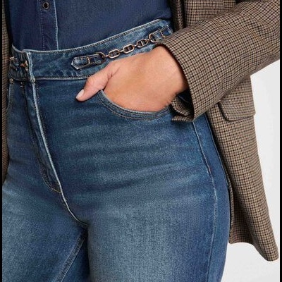 Calças de ganga azul médio com corrente dourada na cintura e casaco xadrez bege