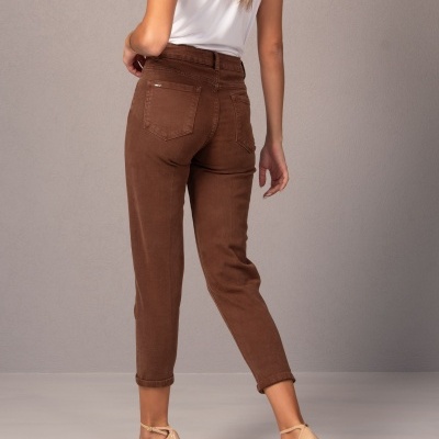 Mulher de costas com calças castanhas de cintura alta, t-shirt branca e salto alto nude