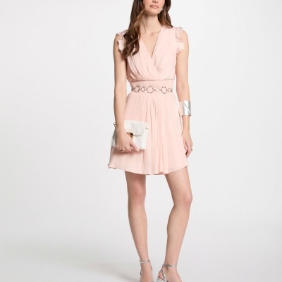 Vestido cor-de-rosa pálido com cinto e acessórios prateados em fundo branco.