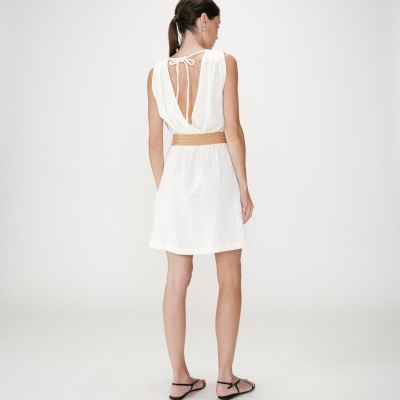 Vestido branco curto sem mangas com cinto castanho e sandálias pretas visto de costas
