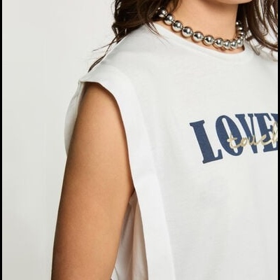 T-shirt branca sem mangas com escrita azul e dourada e colar prateado de bolas