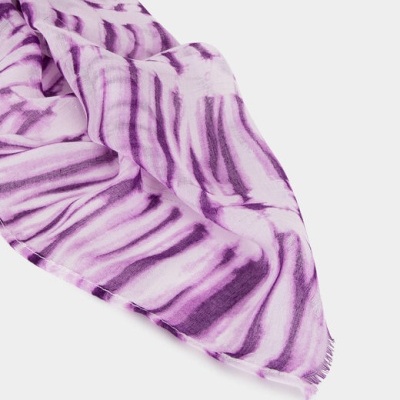 Lenço tecido roxo com padrão tie-dye e franjas.
