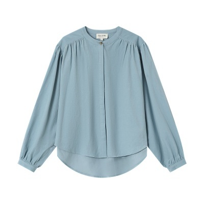 Blusa azul clara de manga comprida com gola redonda e botão dourado