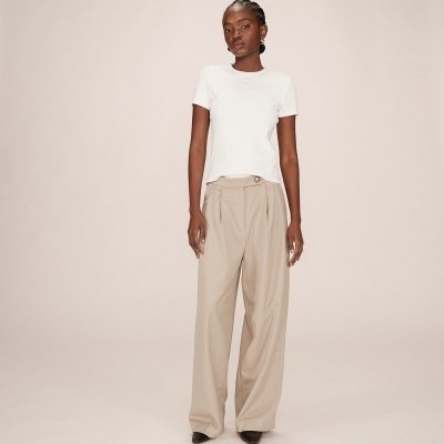 Modelo com t-shirt branca e calças largas bege