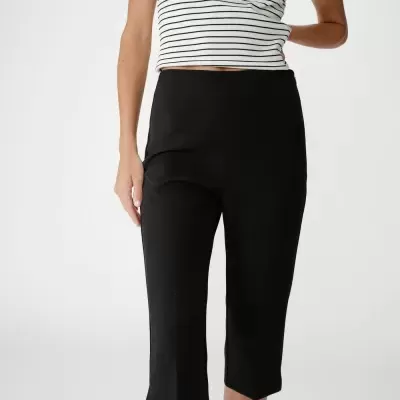 Calças pretas de corte justo até ao meio da perna com top branco às riscas pretas