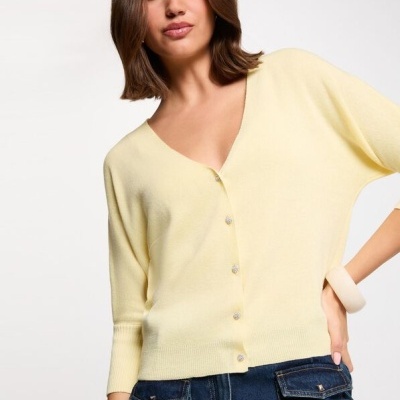 Cardigan amarelo claro com botões brilhantes e calças de ganga azul
