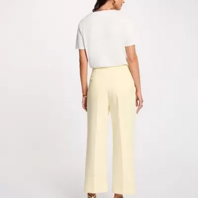 Mulher com t-shirt branca e calças amarelas de costas