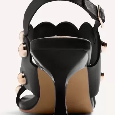 Sandália preta de salto alto médio com botões dourados, vista de trás