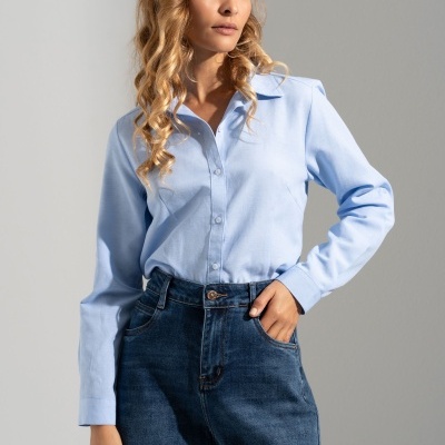 Mulher com blusa de ganga azul clara e calças de ganga azul escura