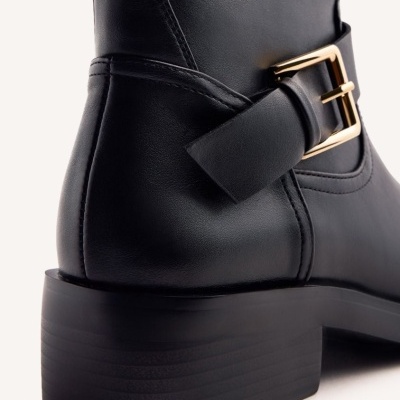Bota preta de couro com salto grosso e fivela dourada