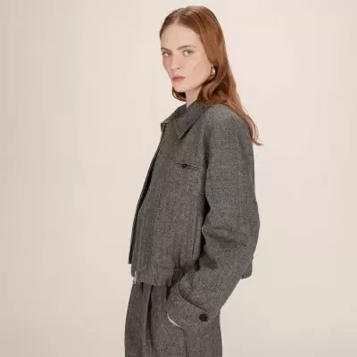 Casaco cinza de corte curto com padrão espinha de peixe e fecho de correr