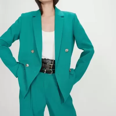 Conjunto feminino verde com blazer e calças, top branco e óculos escuros