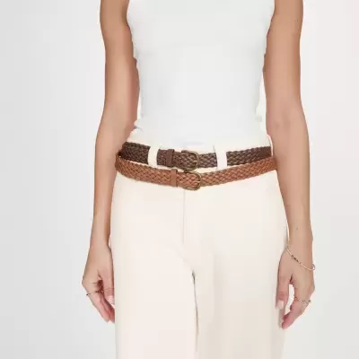 Mulher a usar dois cintos de couro entrelaçado castanho escuro e claro, com calças e camisola branca
