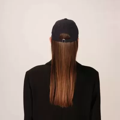 Pessoa de costas com boné preto e cabelo comprido