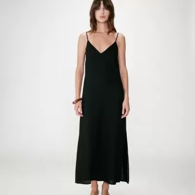 Vestido longo preto com alças finas e sapatos brancos