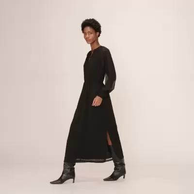 Vestido comprido preto com padrão de pequenos pontos e botas pretas