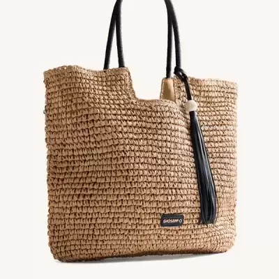 Mala de mão em palha natural com alças pretas e pendente tassel preto com conta branca