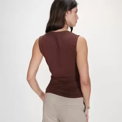 Blusa castanha sem mangas vista de trás com calças bege