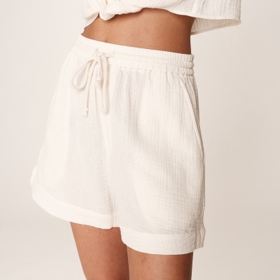 Shorts brancos com cintura elástica e cordão, tecido texturizado.
