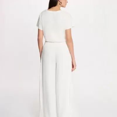 Mulher vista de costas com conjunto branco de t-shirt e calças largas