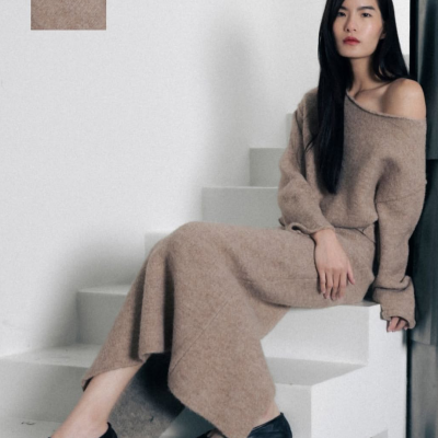 Mulher veste vestido castanho claro em malha com textura suave sentada escadaria branca