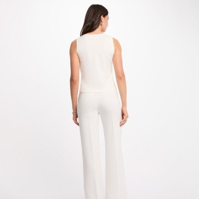 Modelo de costas usando conjunto branco de top sem mangas e calças compridas de corte reto