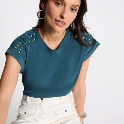 T-shirt azul-petróleo com recortes nos ombros e calças brancas