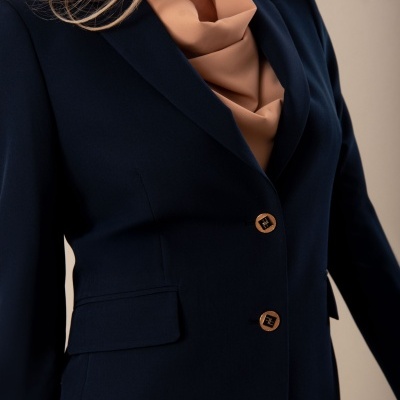 Blazer azul escuro com botões castanhos e camisa bege com gola drapeada