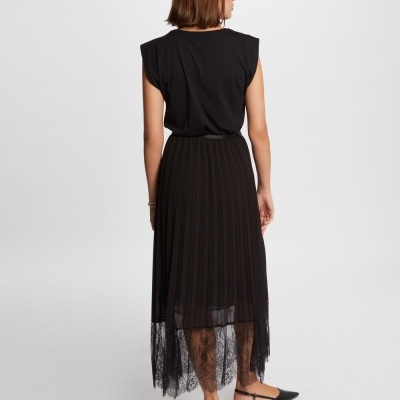 Mulher de costas a usar saia preta plissada com renda e t-shirt preta sem mangas.