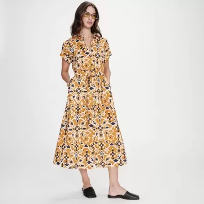 Vestido midi amarelo com padrão geométrico e sapatos pretos