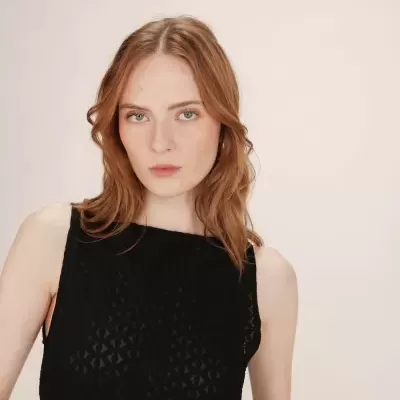 Top preto rendado com padrão geométrico usado por modelo