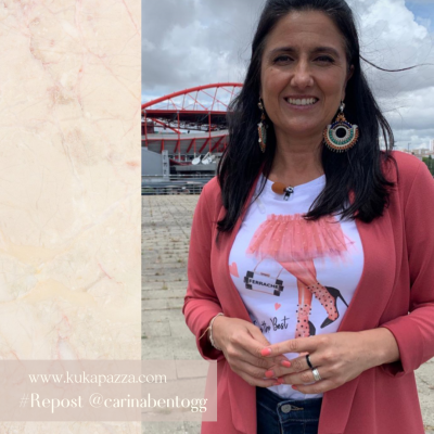 Mulher com t-shirt estampada e casaco cor-de-rosa em ambiente urbano